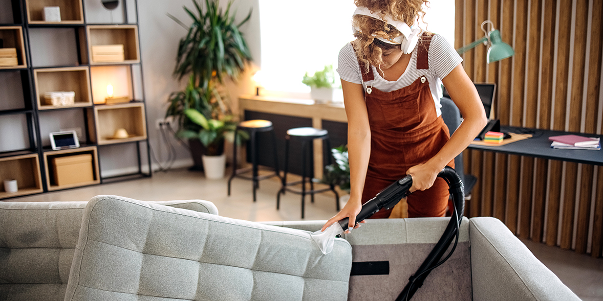 person vacuuming their sofa