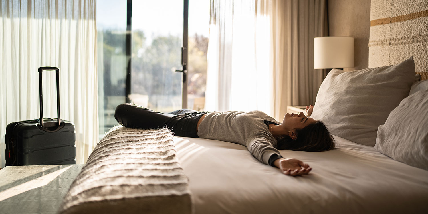 Woman lying on a hotel bed
