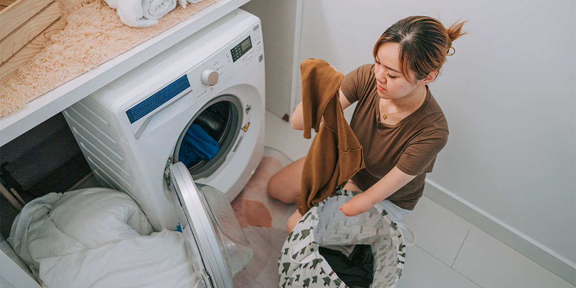 Woman loading washing machine