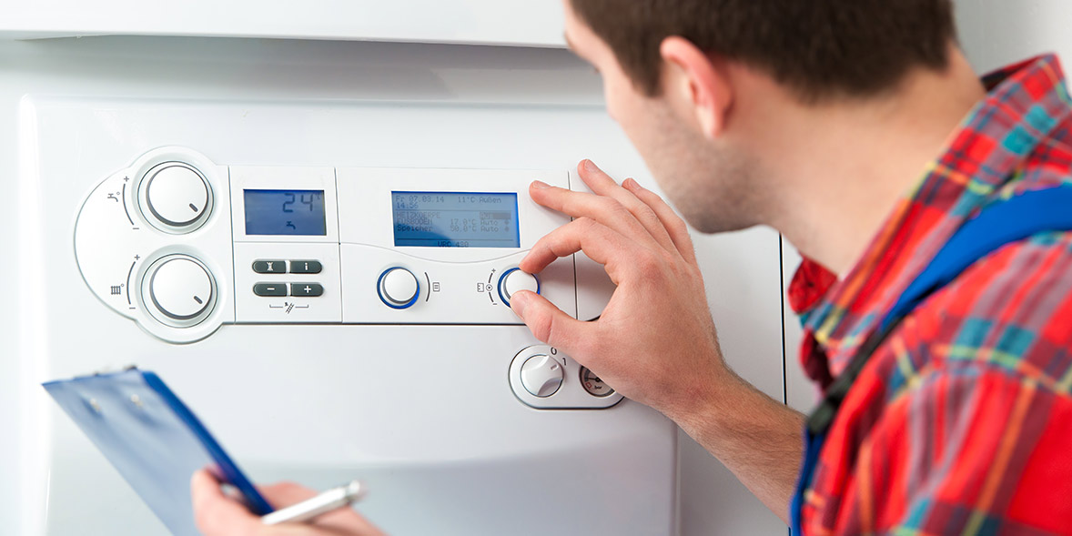 Engineer using the control panel of a boiler
