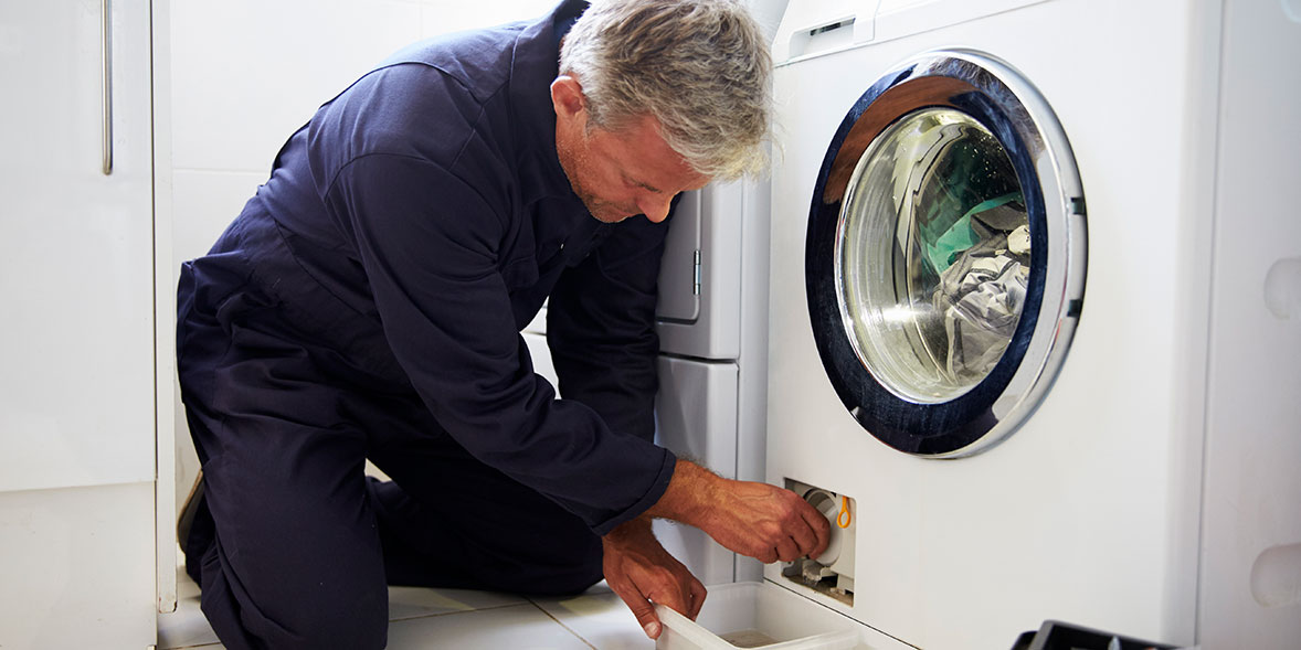 Repairman opening the filter on a washing machine